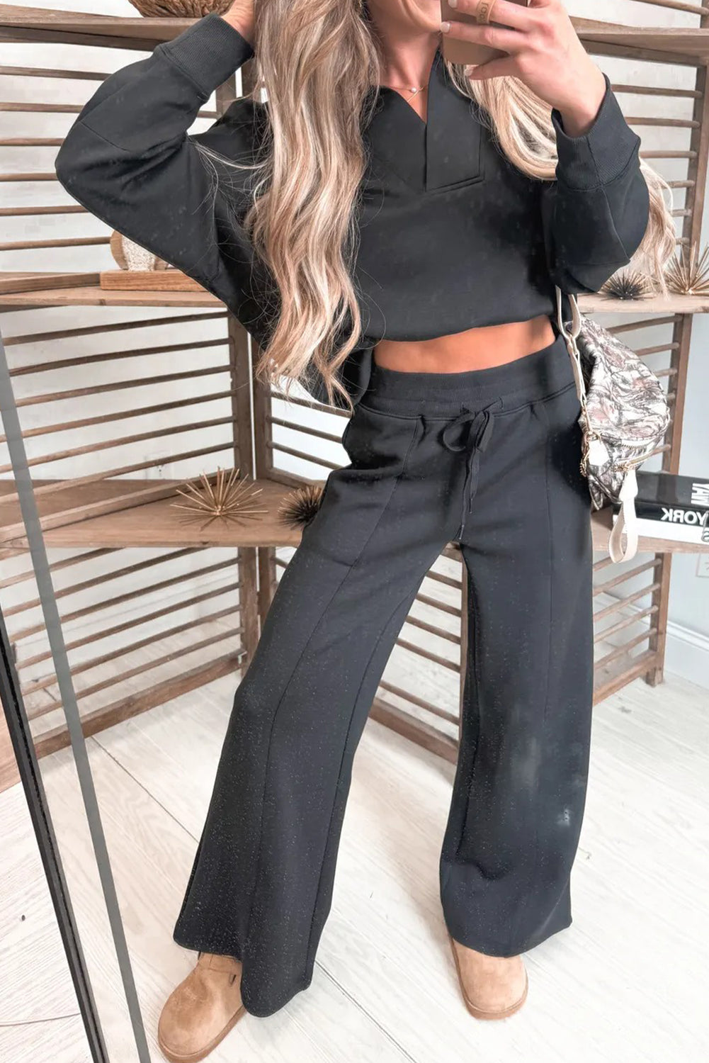 Woman modeling a black collared pullover and matching bottoms set